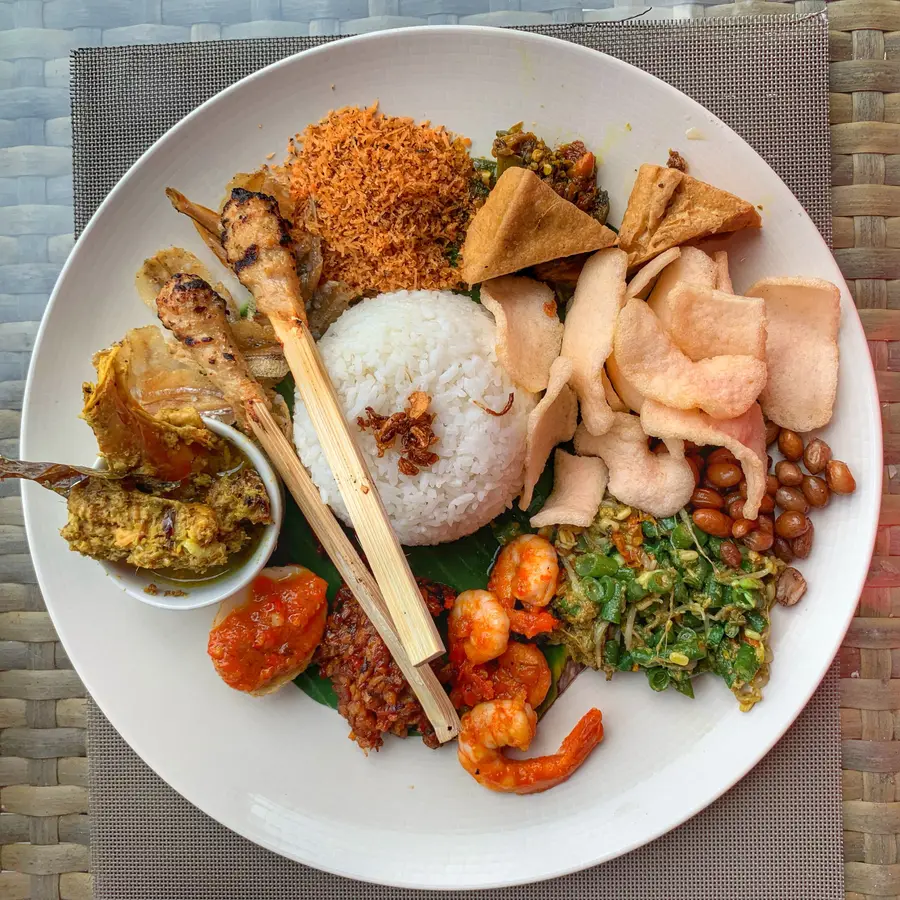 Sepiring nasi campur dengan sate dan sambal