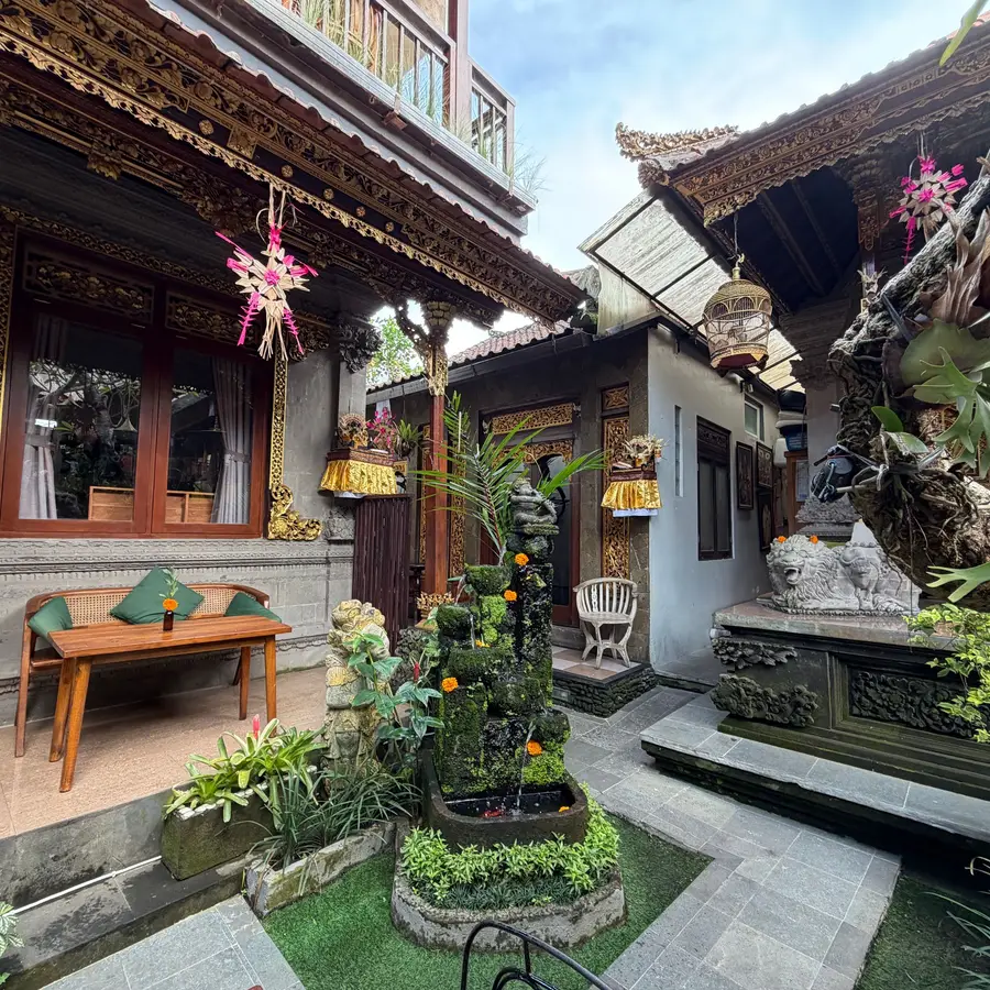 Halaman rumah Bali dengan pintu berukir dan tanaman