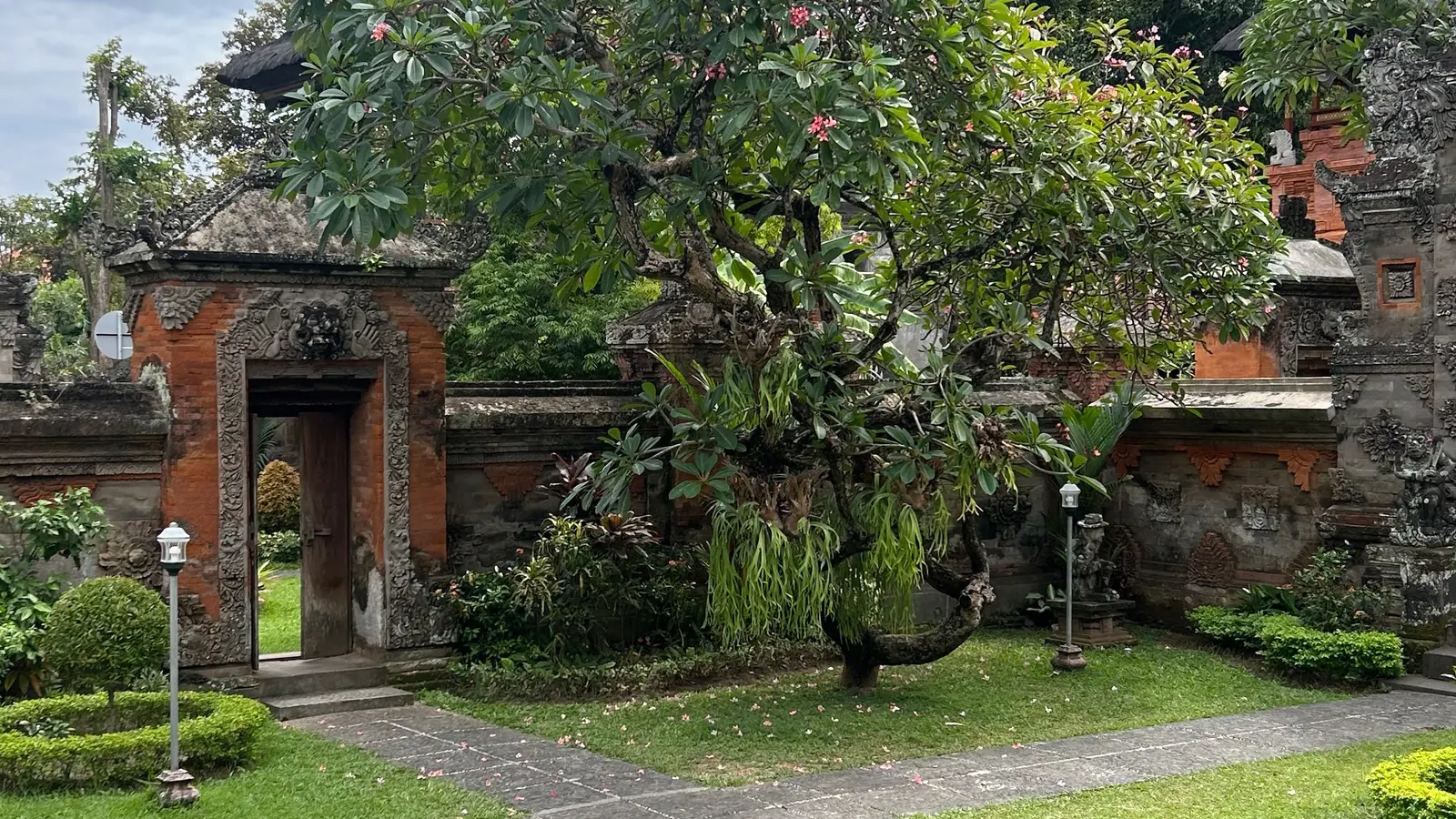Taman hijau di depan bangunan tradisional Bali
