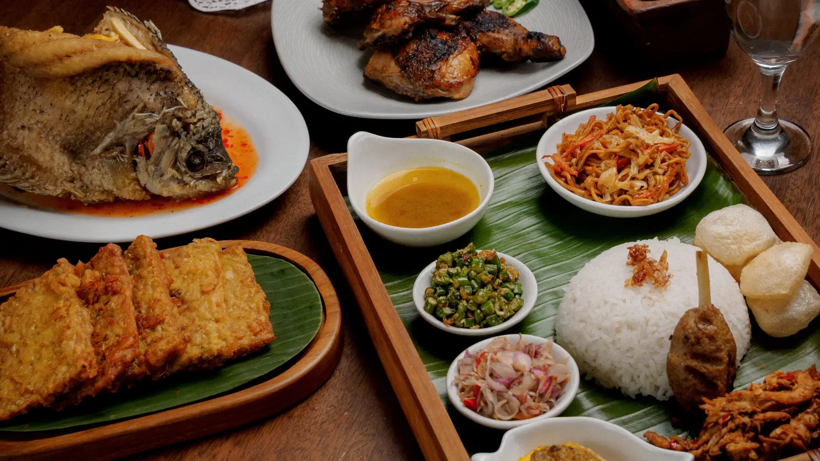 Aneka hidangan Indonesia di atas meja kayu
