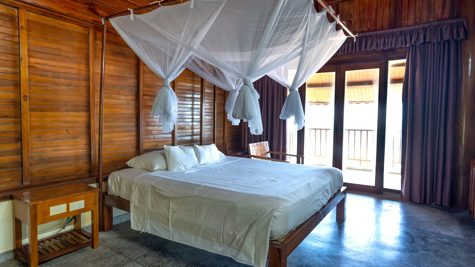 Kamar kayu dengan tempat tidur berkelambu